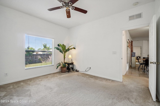 spare room with ceiling fan and light carpet