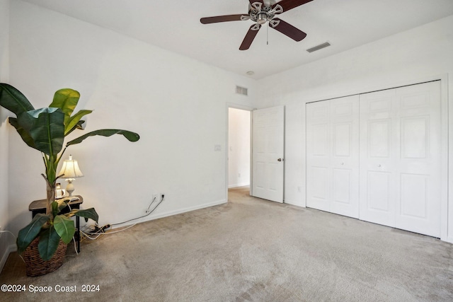 unfurnished bedroom with light carpet, a closet, and ceiling fan