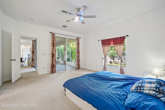 bedroom featuring access to outside, light carpet, multiple windows, and ceiling fan