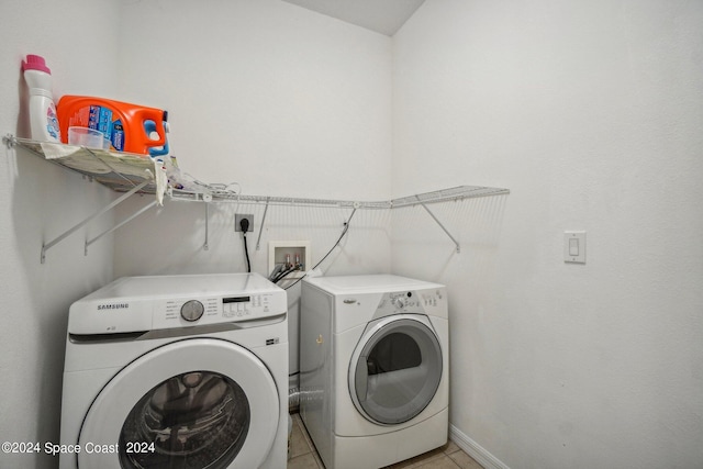 clothes washing area featuring washing machine and dryer and light tile patterned floors