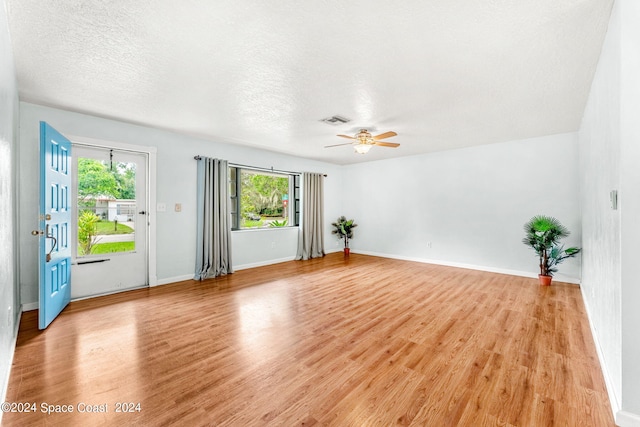 unfurnished room featuring a textured ceiling, light hardwood / wood-style flooring, and ceiling fan