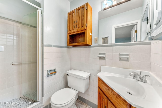 bathroom featuring vanity, toilet, tile walls, and a shower with shower door