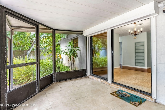 unfurnished sunroom featuring a notable chandelier