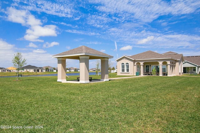 rear view of house featuring a lawn and a gazebo