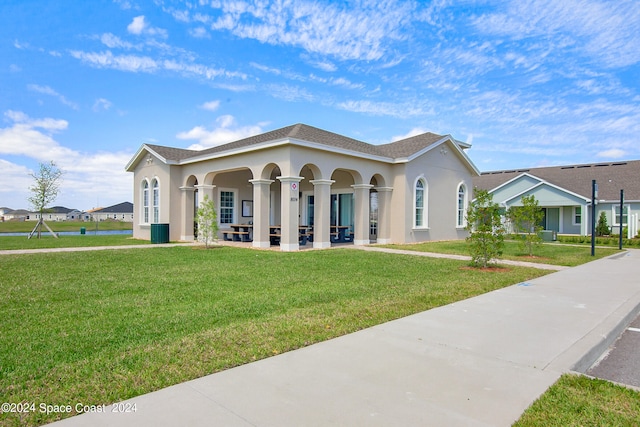 mediterranean / spanish house with a front yard and central air condition unit