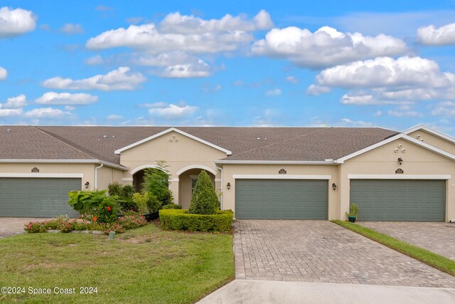 ranch-style home featuring a garage and a front yard