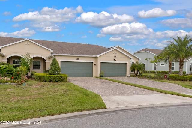 single story home with a garage and a front lawn