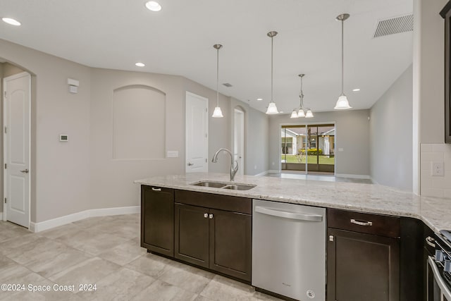 kitchen featuring hanging light fixtures, light stone countertops, appliances with stainless steel finishes, sink, and dark brown cabinetry