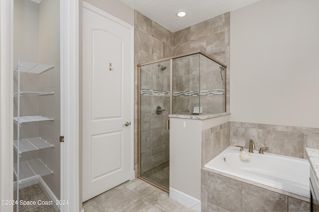 bathroom featuring independent shower and bath, a textured ceiling, and tile patterned floors