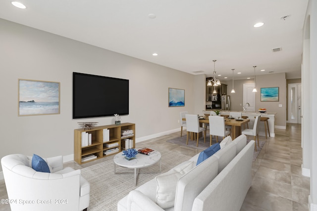 living room featuring an inviting chandelier and sink