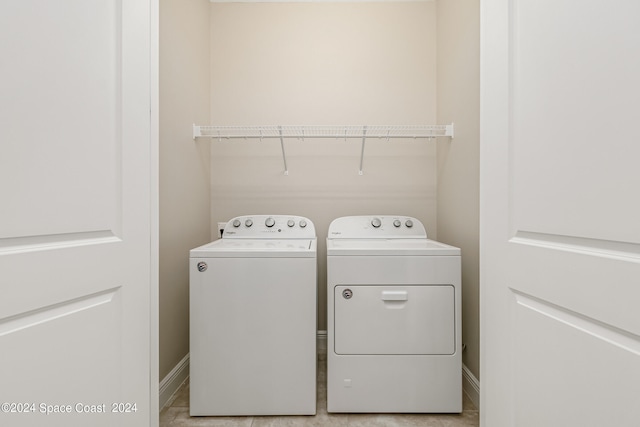 laundry room with washing machine and dryer and light tile patterned flooring