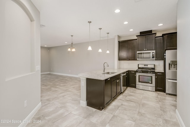 kitchen with decorative light fixtures, light stone counters, stainless steel appliances, sink, and kitchen peninsula