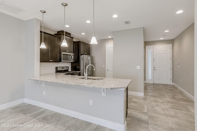 kitchen featuring pendant lighting, stainless steel appliances, a kitchen breakfast bar, kitchen peninsula, and sink