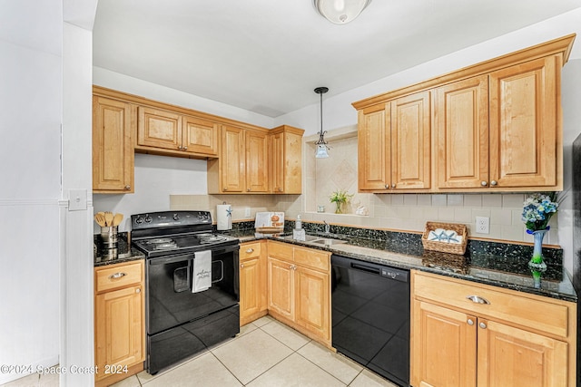 kitchen featuring dark stone counters, backsplash, black appliances, sink, and hanging light fixtures