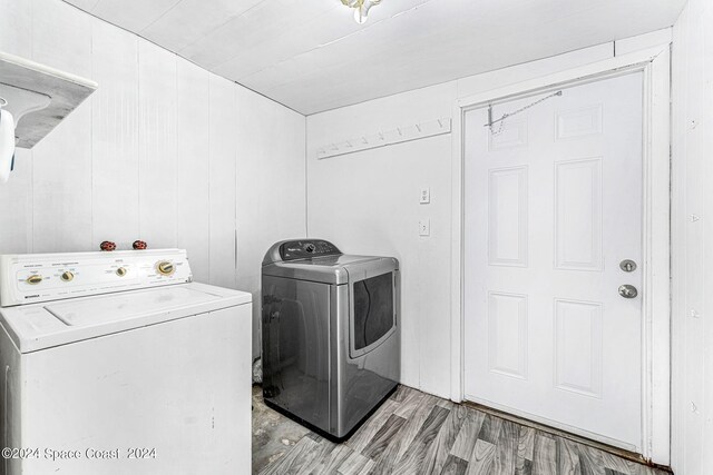 laundry area featuring washing machine and dryer and light hardwood / wood-style flooring