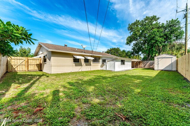 back of property featuring a lawn and a storage unit