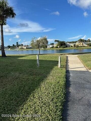 view of home's community with a water view and a yard