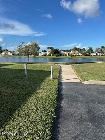 surrounding community with a yard and a water view