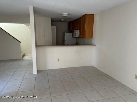 kitchen featuring white appliances and light tile patterned flooring