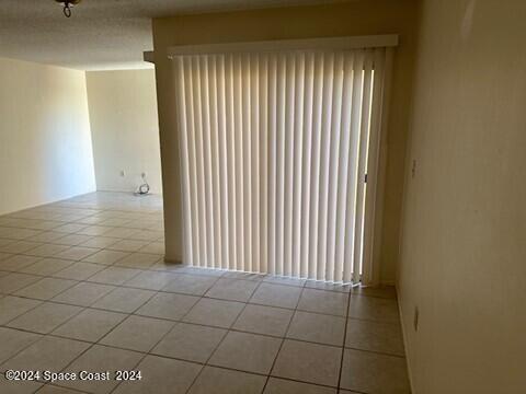 empty room featuring light tile patterned flooring and a textured ceiling