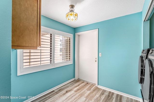 interior space with light hardwood / wood-style flooring, washer and dryer, and a textured ceiling