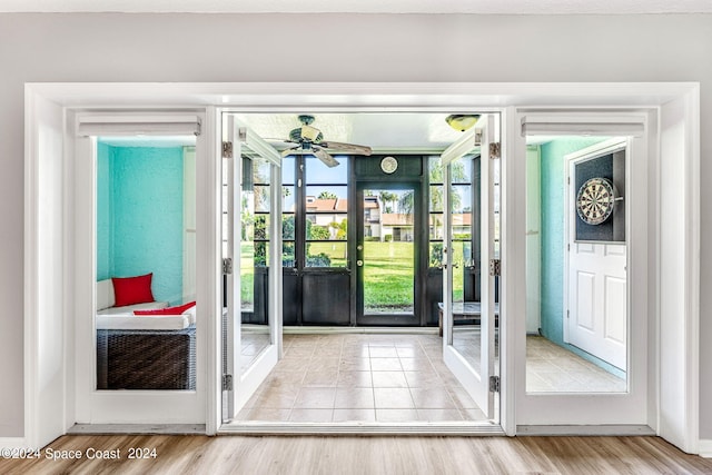 doorway with light hardwood / wood-style floors and ceiling fan