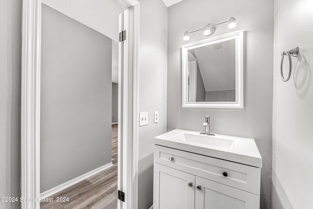 bathroom with vanity, wood-type flooring, and a textured ceiling