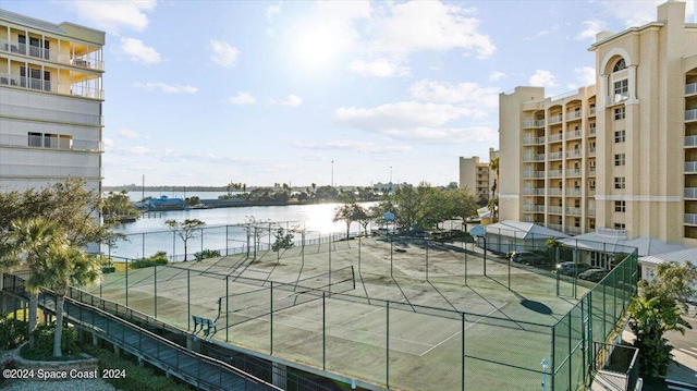 view of tennis court featuring a water view