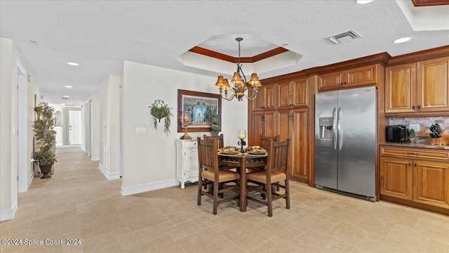 dining room featuring a notable chandelier, a textured ceiling, light tile patterned flooring, and crown molding