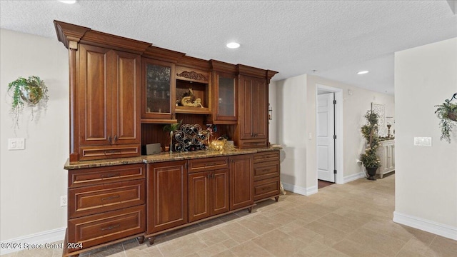 bar with stone counters and a textured ceiling