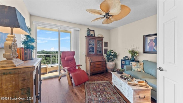 living area featuring ceiling fan and dark hardwood / wood-style flooring