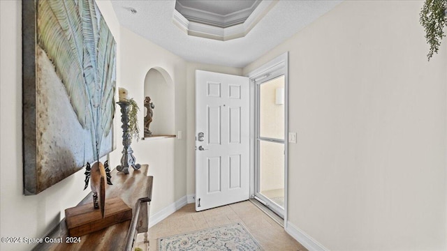 tiled entrance foyer with crown molding and a textured ceiling