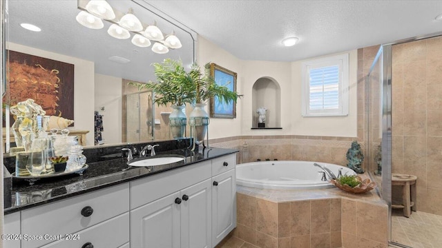 bathroom with vanity, independent shower and bath, a textured ceiling, and tile patterned floors