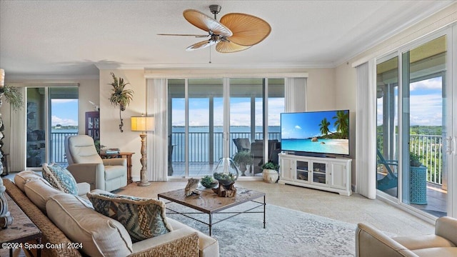 living room featuring ceiling fan, crown molding, a textured ceiling, and a wealth of natural light