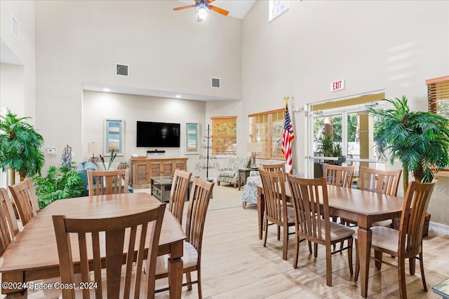 dining space with high vaulted ceiling, light wood-type flooring, and ceiling fan