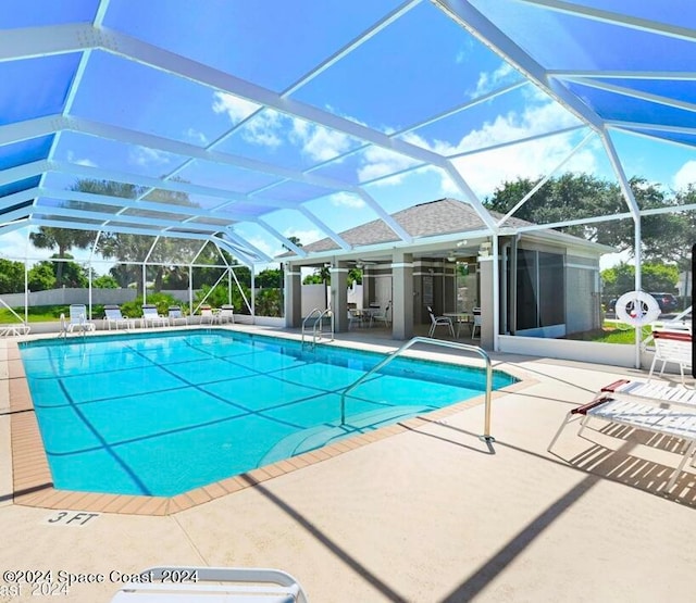 view of swimming pool with glass enclosure and a patio area