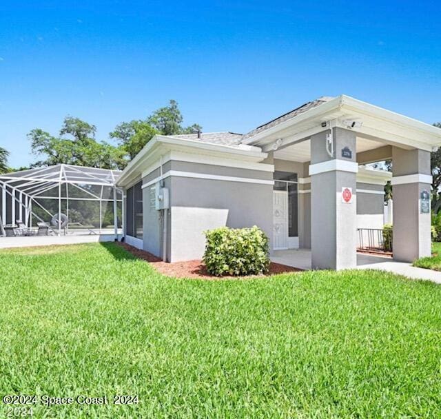 exterior space with a lanai and a lawn