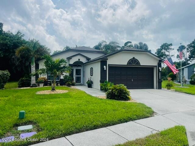 ranch-style home with a garage and a front lawn