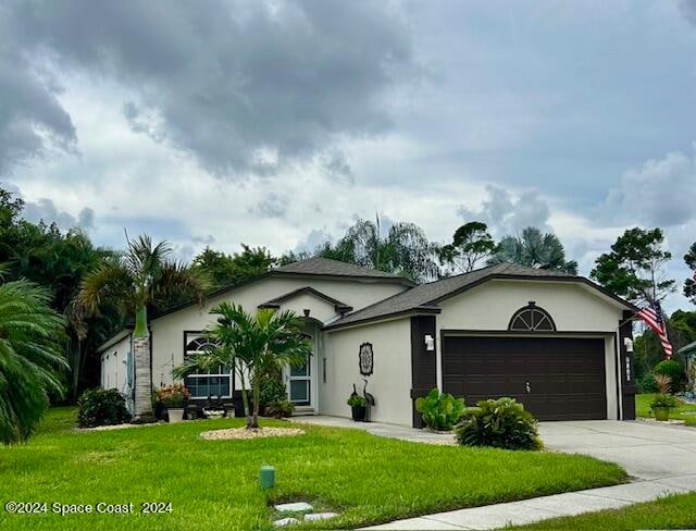 single story home featuring a garage and a front yard