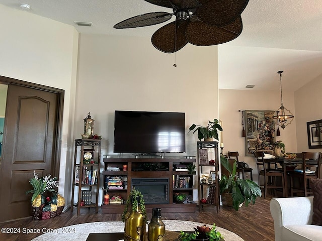 living room with a chandelier, dark wood-type flooring, and a textured ceiling