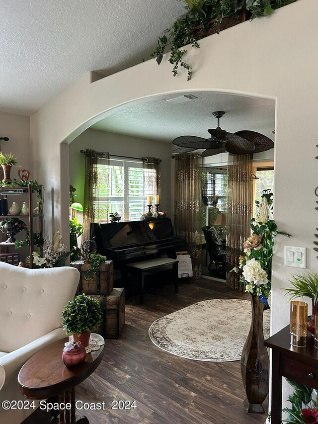 living room featuring hardwood / wood-style floors, a textured ceiling, and ceiling fan