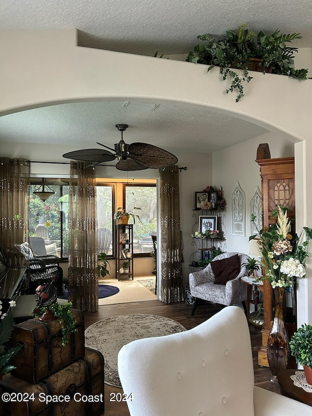 living room featuring a textured ceiling and ceiling fan