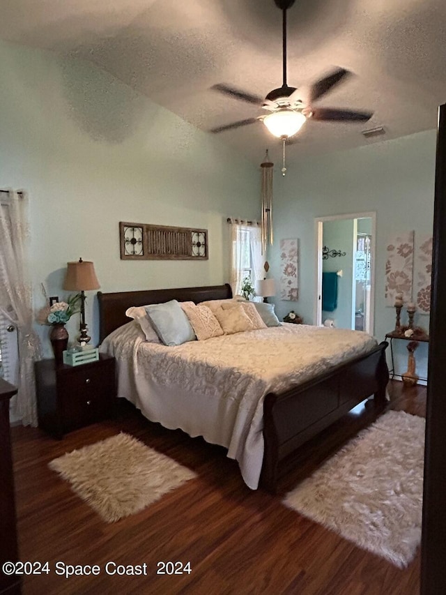 bedroom featuring ceiling fan, dark hardwood / wood-style floors, a textured ceiling, and ensuite bath