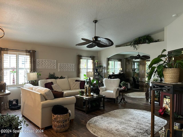 living room with vaulted ceiling, ceiling fan, dark hardwood / wood-style flooring, and a textured ceiling