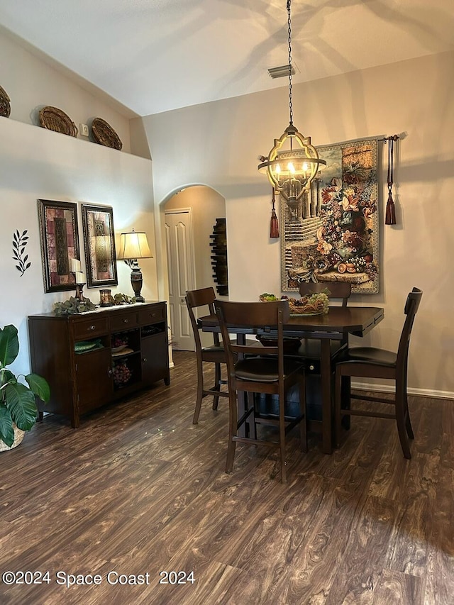 dining room with dark hardwood / wood-style flooring and a notable chandelier