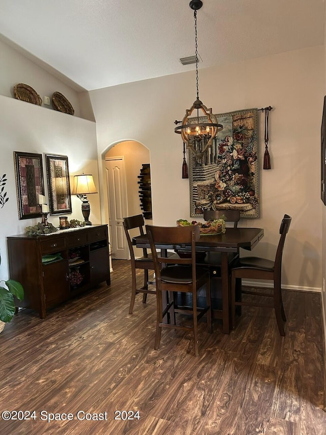 dining area featuring dark hardwood / wood-style floors and a chandelier