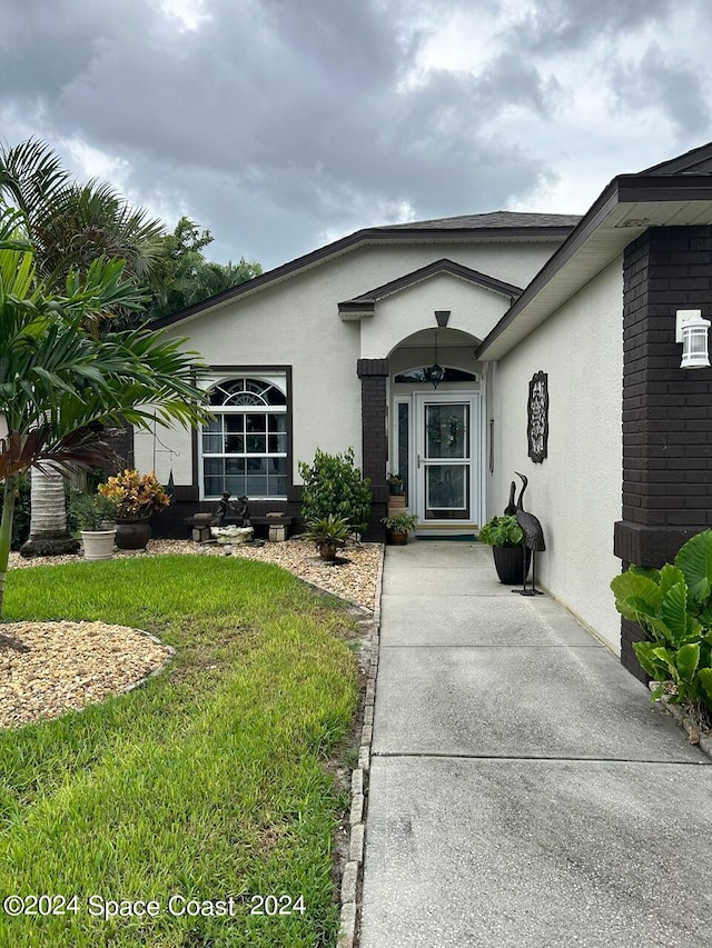 property entrance with a lawn