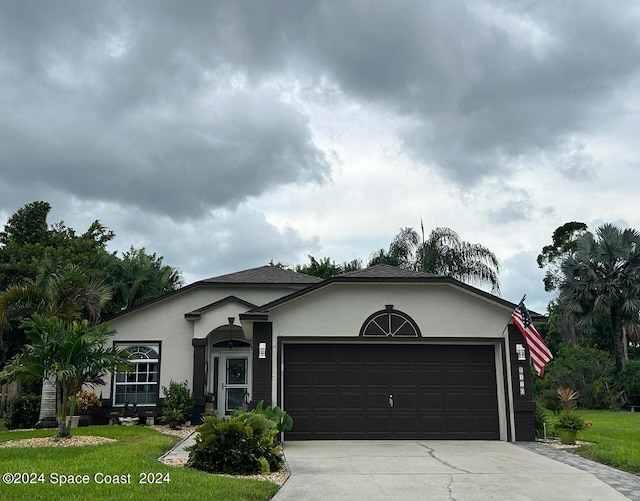 ranch-style home featuring a garage and a front lawn