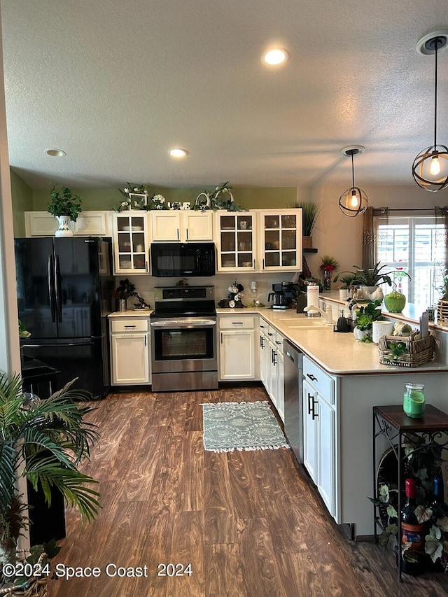 kitchen featuring a textured ceiling, black appliances, decorative light fixtures, white cabinets, and dark hardwood / wood-style floors