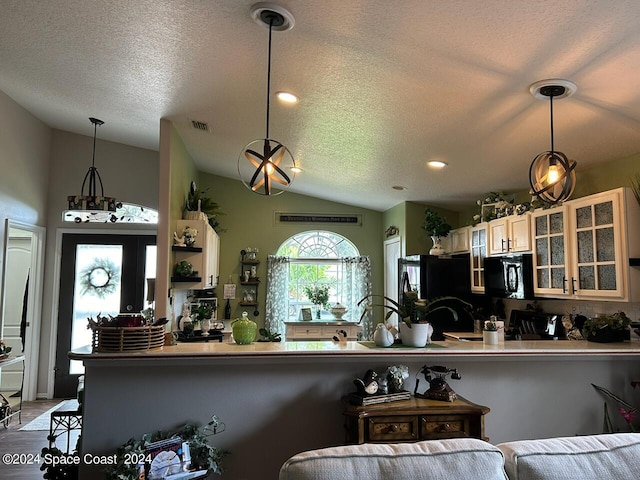 kitchen with kitchen peninsula, a textured ceiling, vaulted ceiling, and black appliances